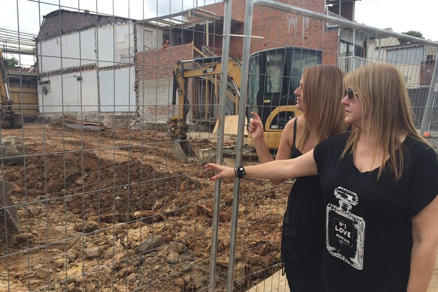 Lulu Ross (right) and her daughter Eleni Endt look at the site where their hair salon once was.