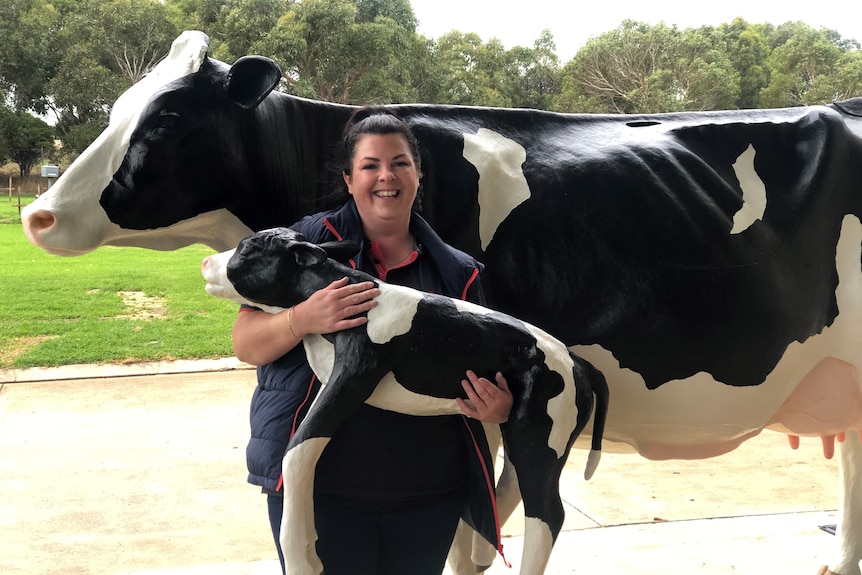 Agriculture teacher Rebecca Toleman standing with the cow simulator