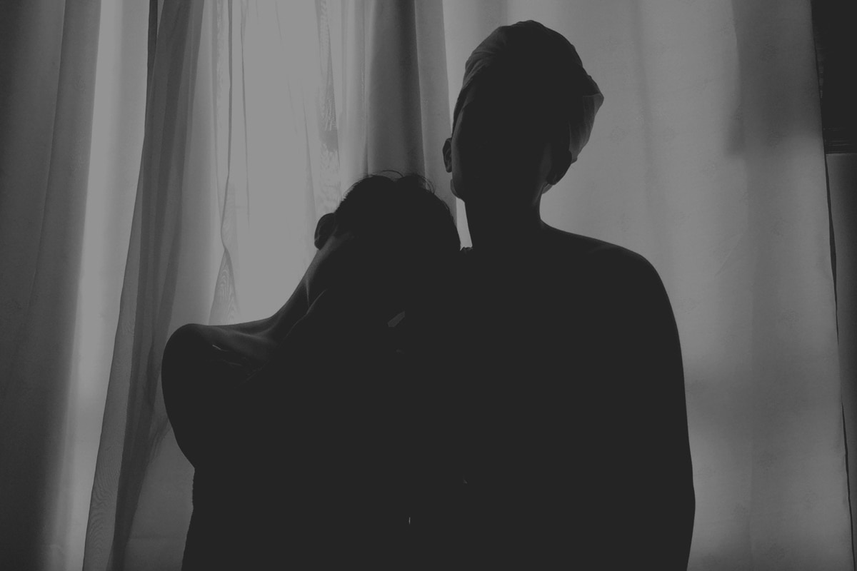 Couple in bed with the lights off.