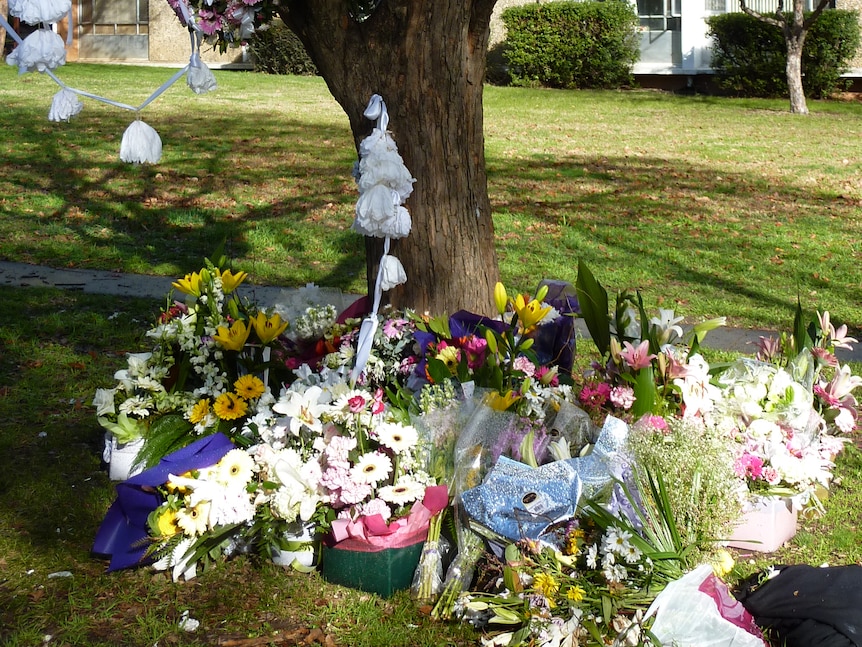 A memorial of flowers and notes in tribute to a man murdered outside the Northbourne flats in Canberra.
