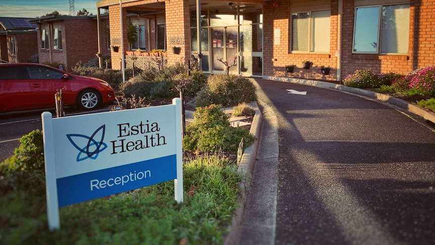 A sign reads 'Estia Health Reception' outside a one-storey brick building.