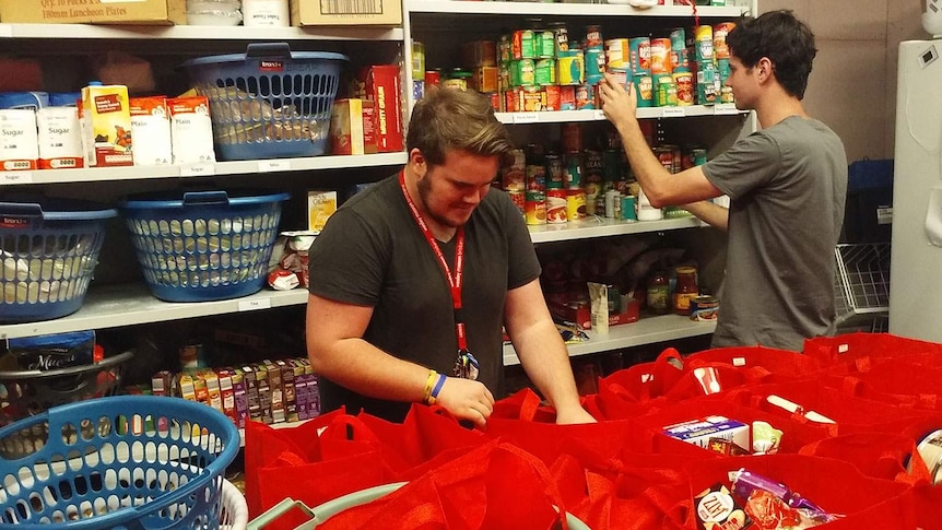 Wesley Mission Brisbane volunteers packing and sorting red bags for Christmas hampers