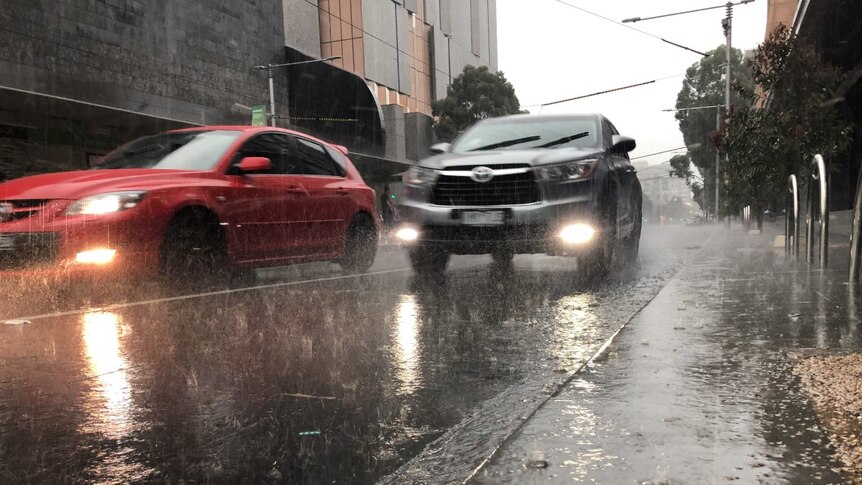 Cars driving through heavy rain and puddles at Southbank.
