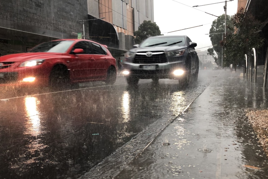 Cars driving through heavy rain and puddles at Southbank.