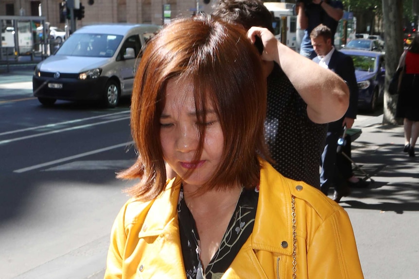 Thi Nguyen walks with her head down outside the Melbourne Magistrates' Court.