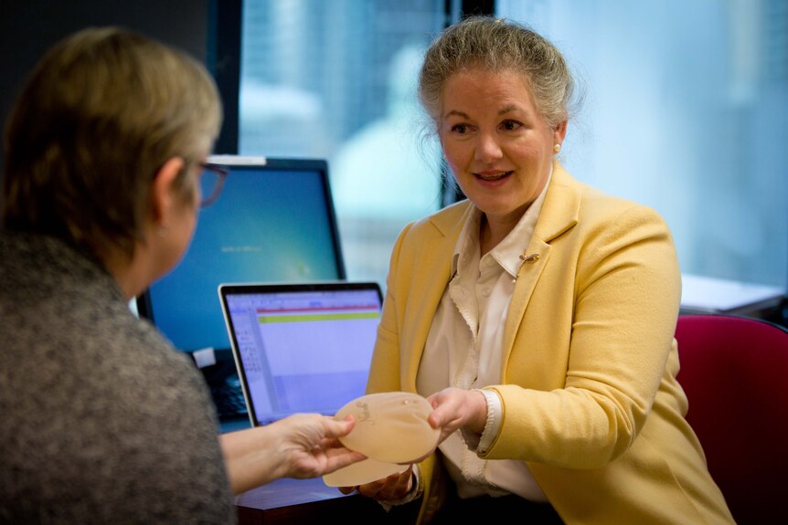 Dr Elizabeth Rippy shows a breast cancer patient two silicon implants at a clinic in Sydney.