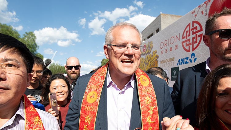 Scott Morrison walking through a crowd at a Chinese New Year celebration.