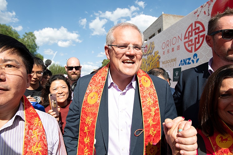 Scott Morrison walking through a crowd at a Chinese New Year celebration.