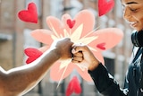 Man and woman fist pumping with illustrated hearts coming from their fists to depict being friends with an ex.