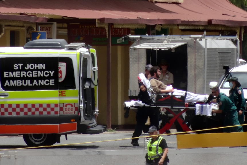 Man on a stretcher is put into an ambulance