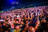 A huge crowd of people holding up their phones at a night time gig