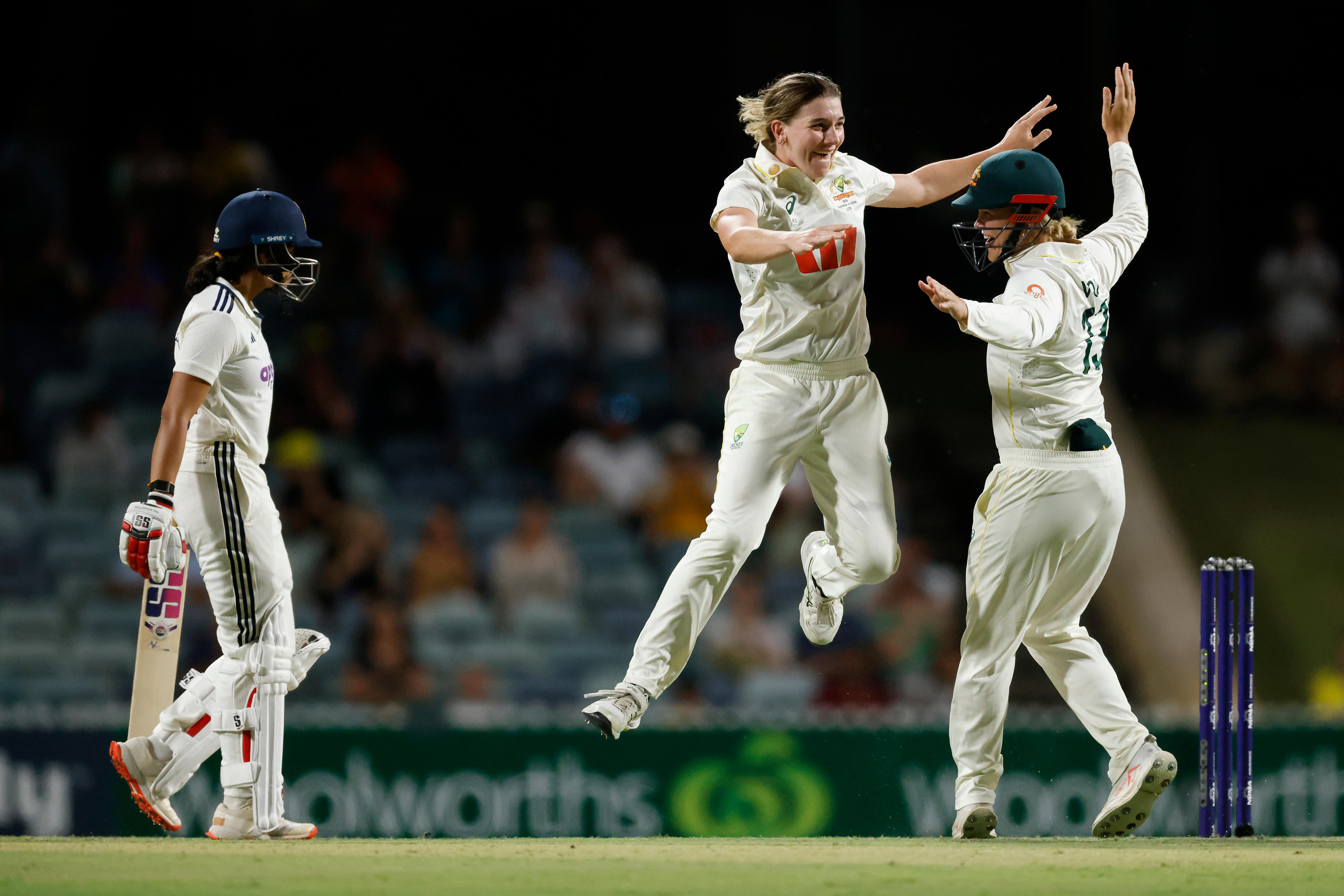 Annabel Sutherland jumps to high five a teammate as Jemimah Rodrigues walks off.