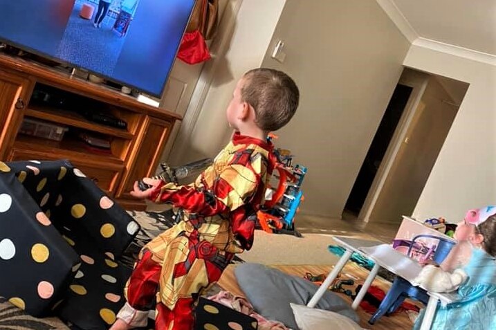 A young boy and girl watching a video on a video at home