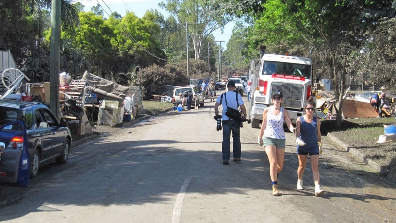 People help clean up a street which flooded in Rocklea on Brisbane's southside on January 16, 2011.