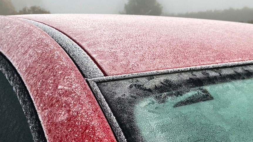 Ice on a car windshield on a foggy morning.