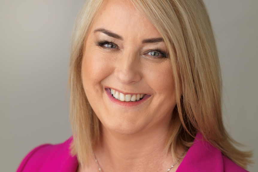 A blonde woman in a magenta blazer