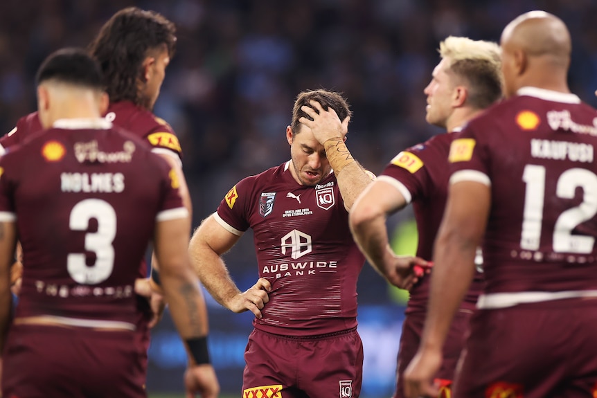 Ben Hunt puts his hand in his hair sadly. Other Queensland Maroons are in the foreground during State of Origin II.