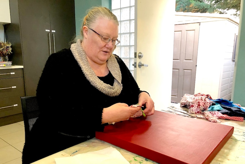 Angela Rose sits at a table.