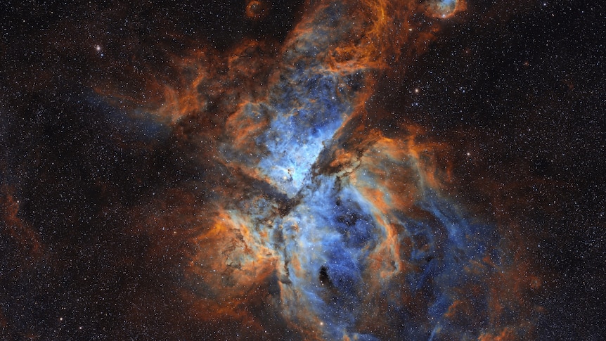 A close up of a nebula gas with orange and blue colours 