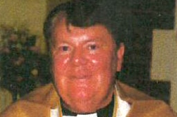 Close-up shot of priest Raymond Cheek wearing a gold robe