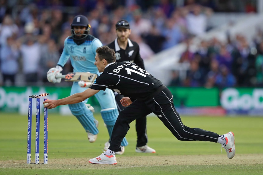 Trent Boult holds out his hand when holding the ball and flicks off the bail as Adil Rashid  runs