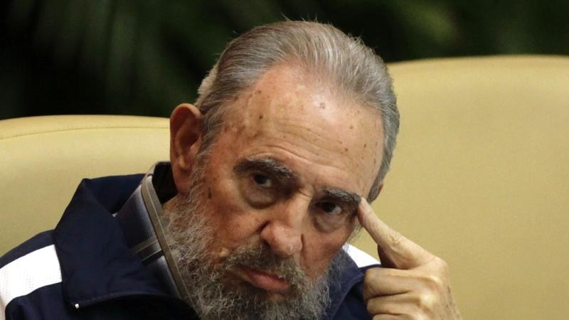 Fidel Castro sits with his finger poised at his temple