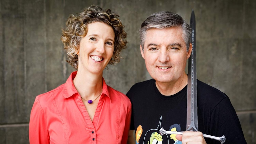 Cristy Burne and Denis Knight facing the camera smiling. Denis has a sword on his shoulder