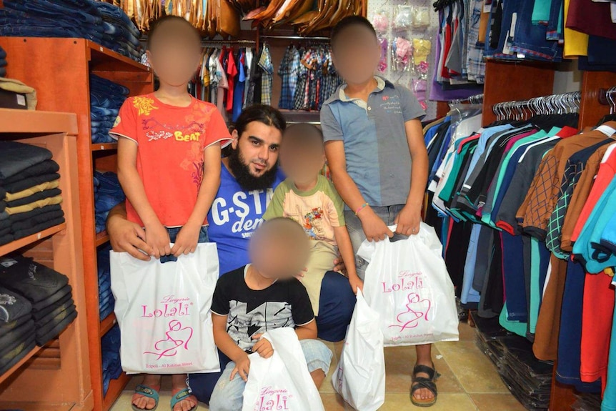 Adnan Baradaaji with children standing around him.