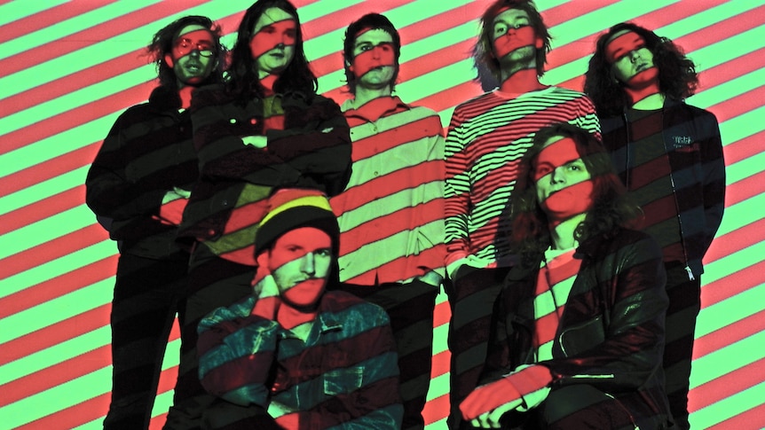 A 2016 press shot of King Gizzard and the Lizard Wizard shaded in red and green stripes