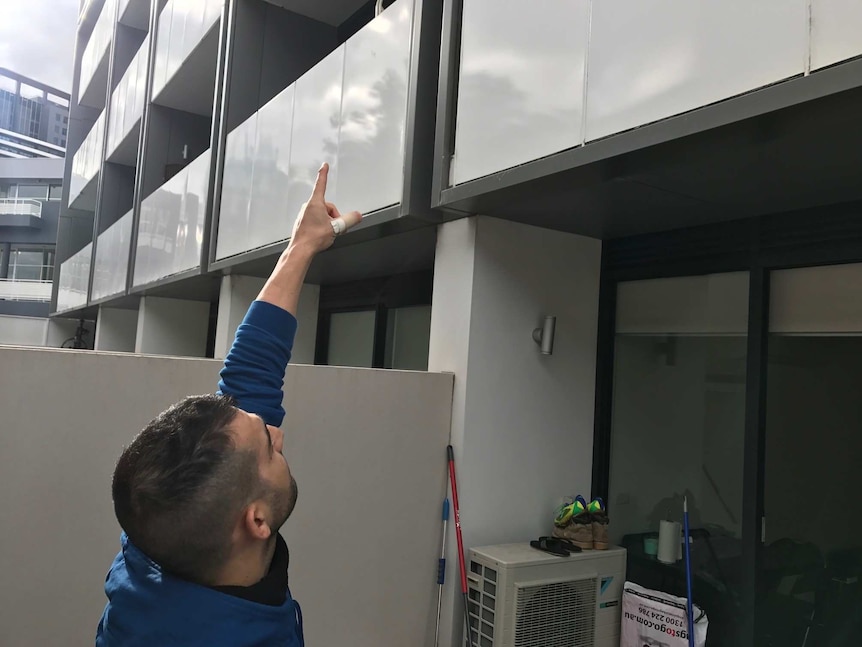 Giovanni Pittalis points to the external cladding on the apartment building where he lives.