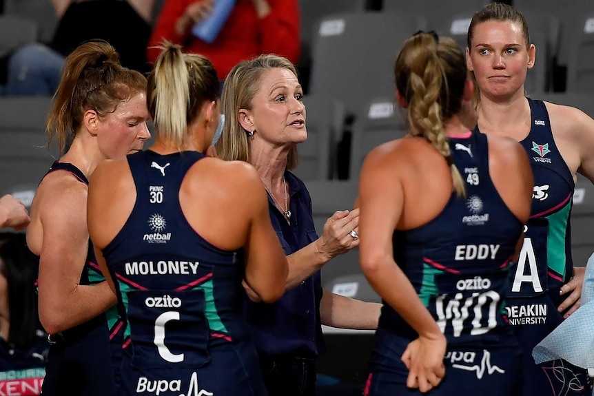 Simone McKinnis speaks while standing in the middle of four Vixens players