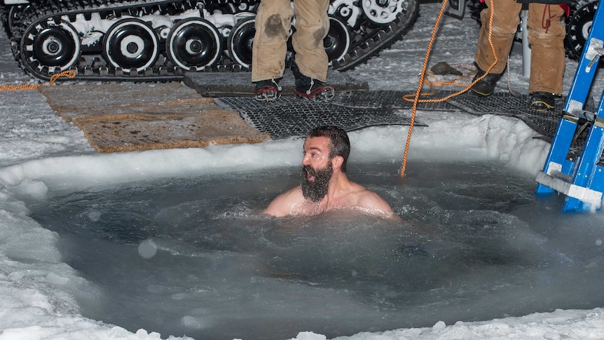 A member of the Antarctic Division's Davis research station team takes a plunge to mark the 2014 winter solstice.