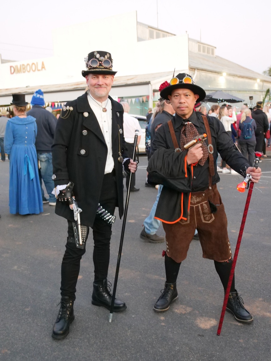 Two men dressed up in steampunk costumes pose.