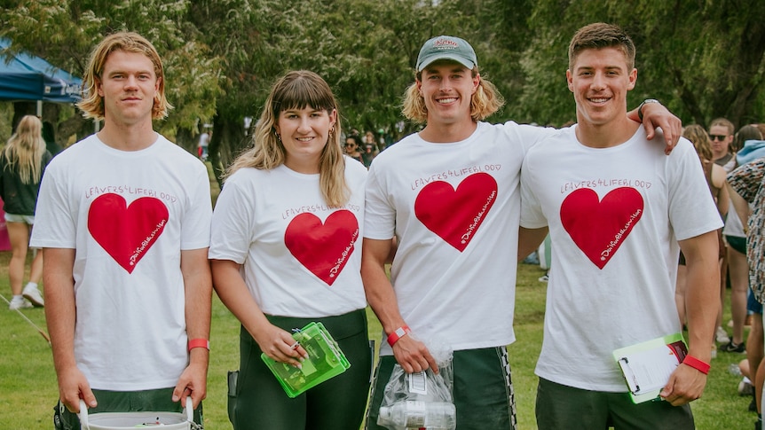 fOUR YOUNG PEOPLE STAND WEARING SHIRTS WITH RED HEARTS ON THEM