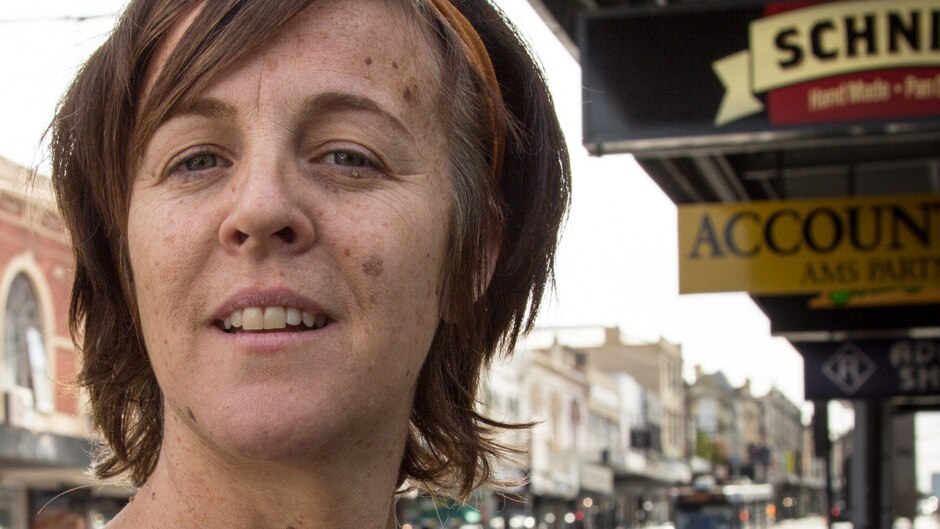 A woman in the street of an inner-city suburb.