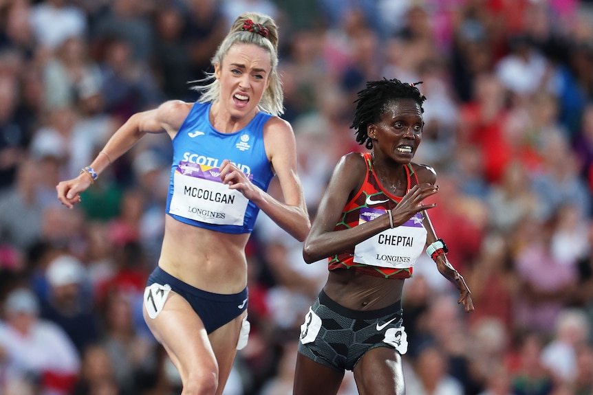 Un atleta escocés corre hacia el hombro de un rival de Kenia en la última curva de una final de 10.000 m, mientras ambos corredores hacen una mueca.