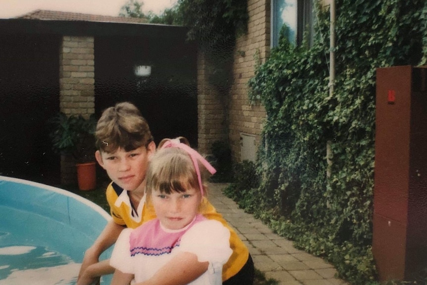 A young boy and girl pictured next to a swimming pool