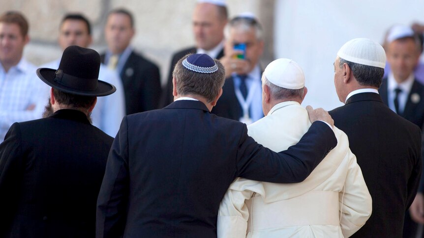 Rabbi Abraham Skorka places his arm around Pope Francis with Omar Abboud at the Wall in Jerusalem