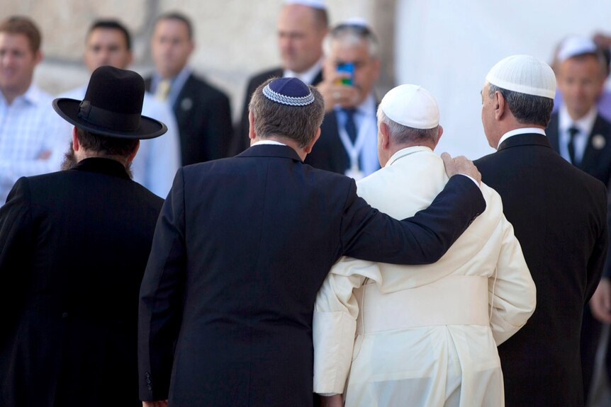 Rabbi Abraham Skorka places his arm around Pope Francis with Omar Abboud at the Wall in Jerusalem