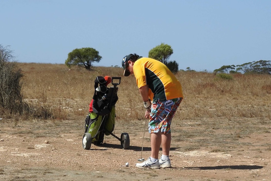 Golfer putting in the rough on Nullarbor Links golf course