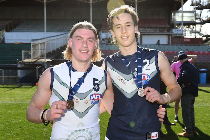 Harley Reid and Ollie Murphy pose for a photo, both wearing medals around their necks