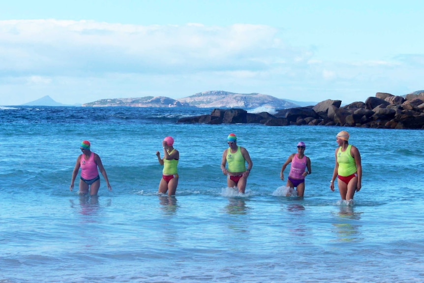 The group walk out of the sea