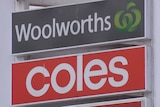 A sign for Woolworths on top of another for Coles