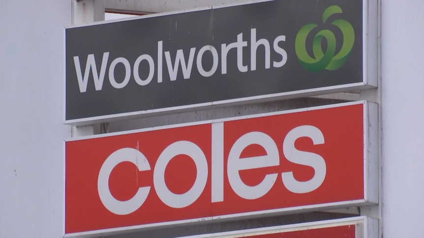 A sign for Woolworths on top of another for Coles