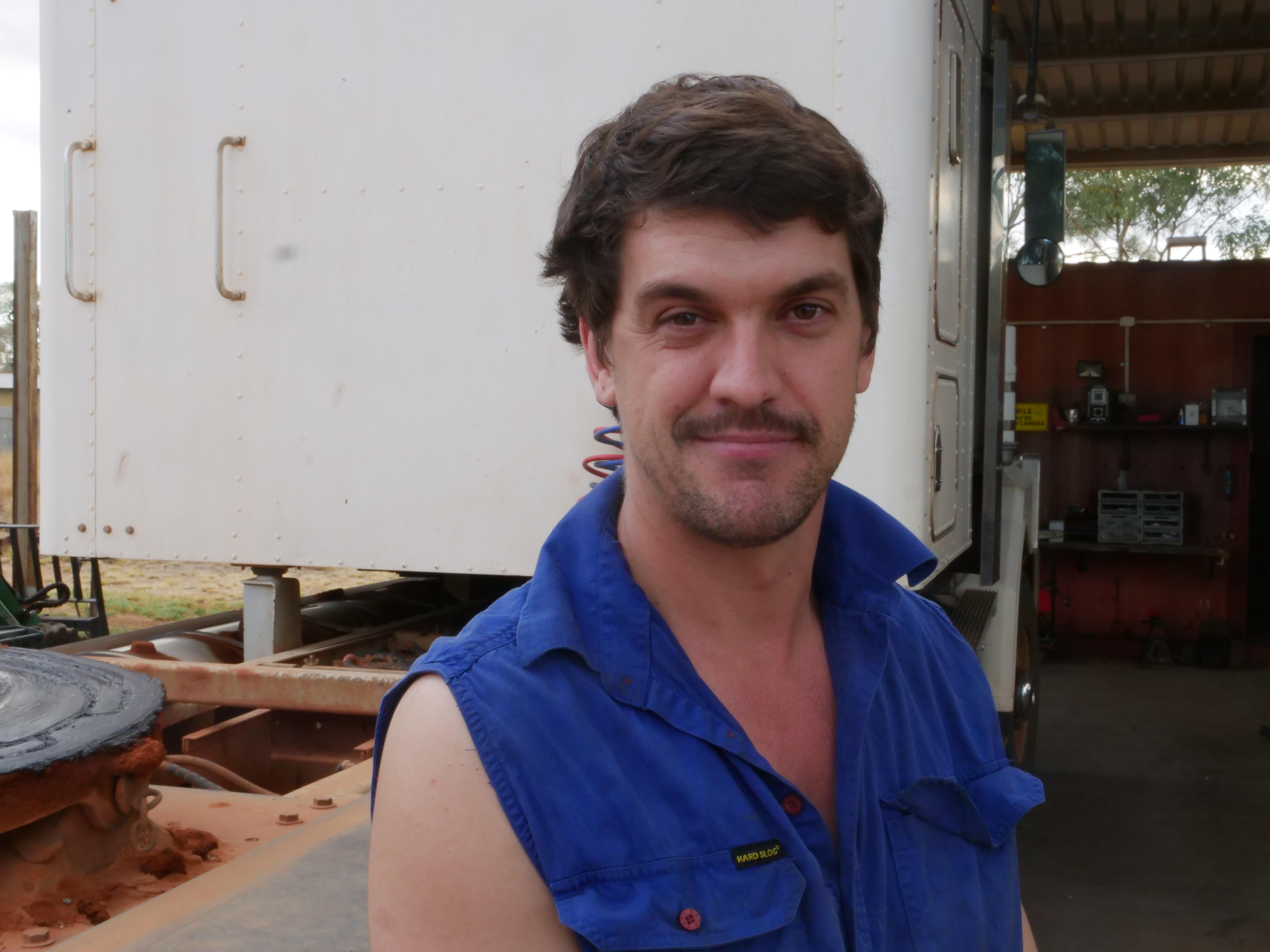 a man standing in front of a truck.