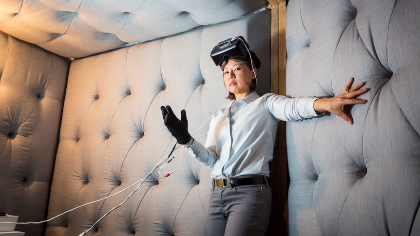 The artist Eugenie Lee invites you into a padded room, she has a glove and VR headset on