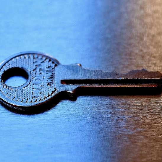 Picture of a key on a table in a darkly lit room 