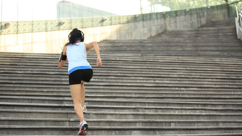 A woman exercising by running up steps