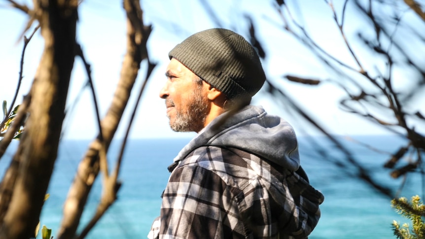 Warren Foster with a Melaleuca tree in the foreground looking out to sea