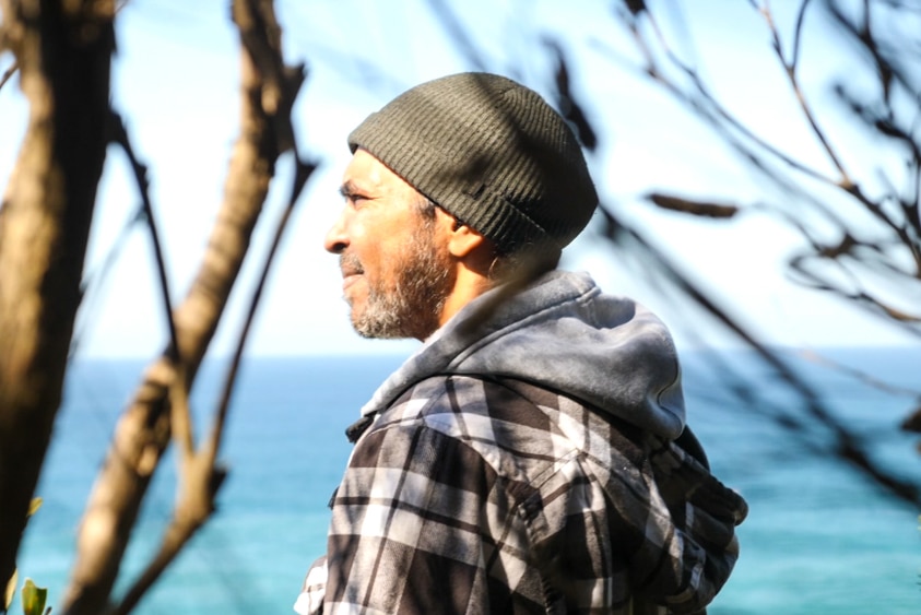 Warren Foster with a Melaleuca tree in the foreground looking out to sea